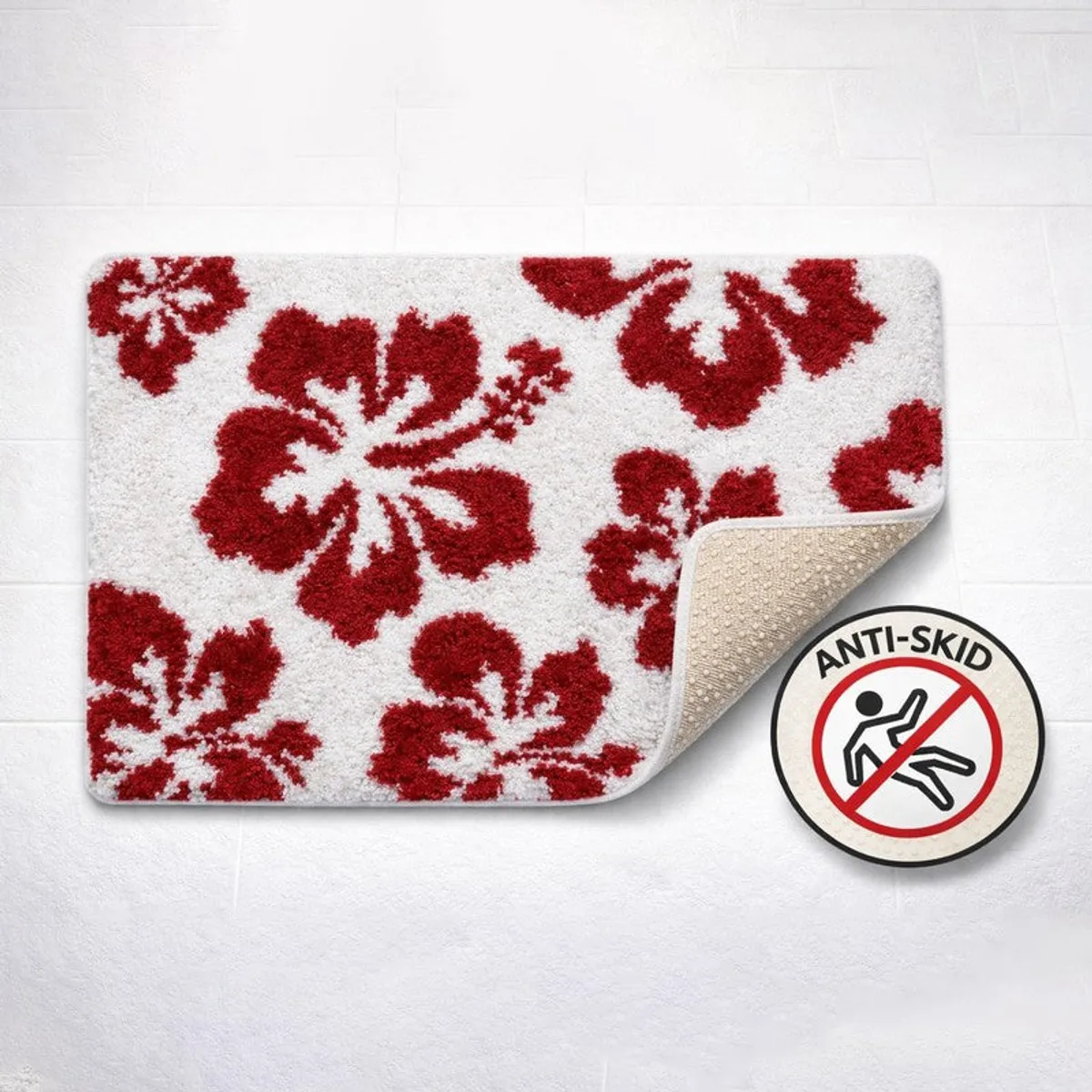 Red and white floral bath mat with corner lifted to show anti-skid backing