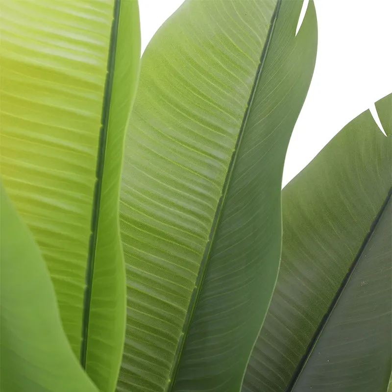 Close-up view of the artificial plant's layered green leaves