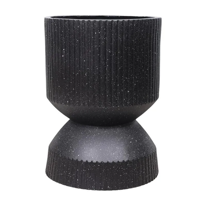 Close-up view of the black ribbed planter's sculptural hourglass form.