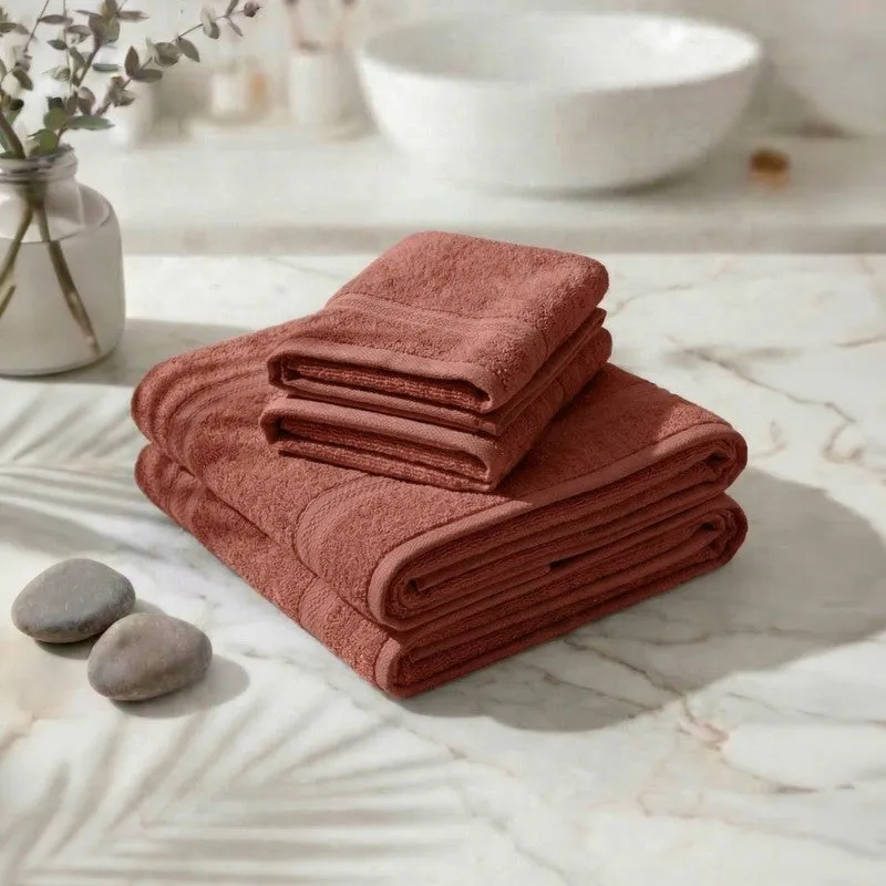 Folded rust towel set arranged on a marble surface
