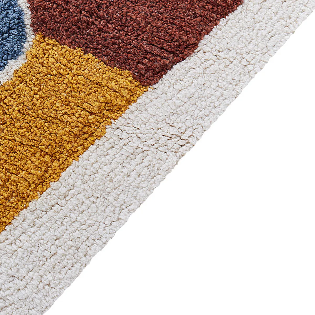 Close-up view of the rug’s soft textured pile along the cream border and yellow boat section.