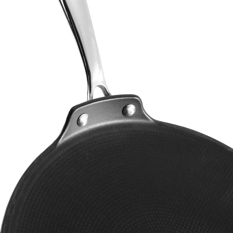 Close-up view of the black tawa surface and silver handle joint