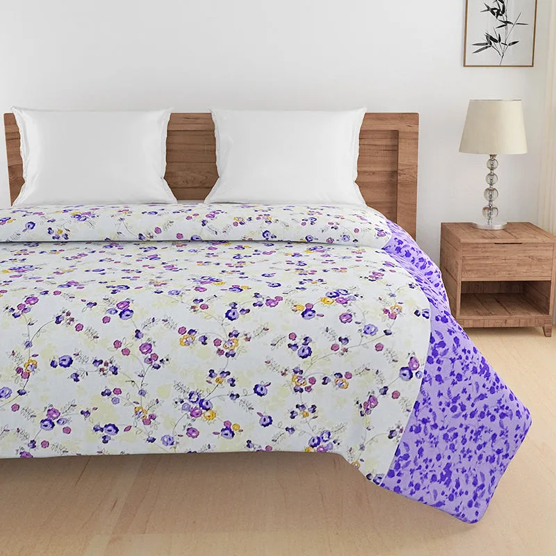Floral comforter covering a bed with a purple patterned border