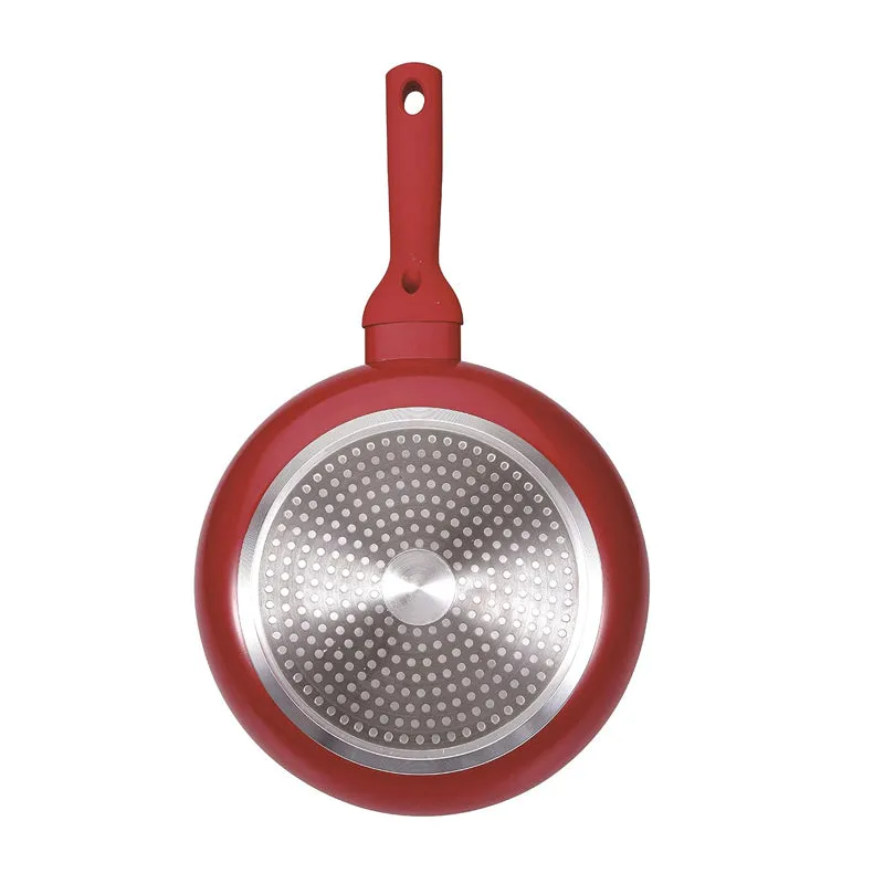 Underside of a red frypan showing its circular metallic base