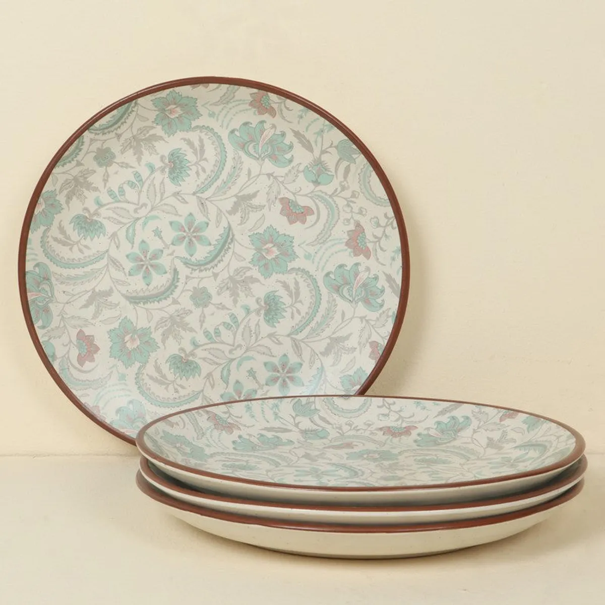 Floral and paisley-patterned ceramic plates shown in a layered arrangement.