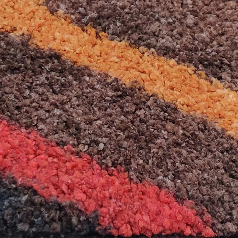 Detailed close-up of the rug pile in brown, tan and red tones