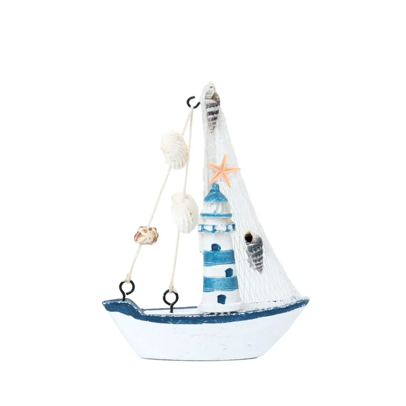 Front view of a white and blue sailboat showpiece with lighthouse and shell details