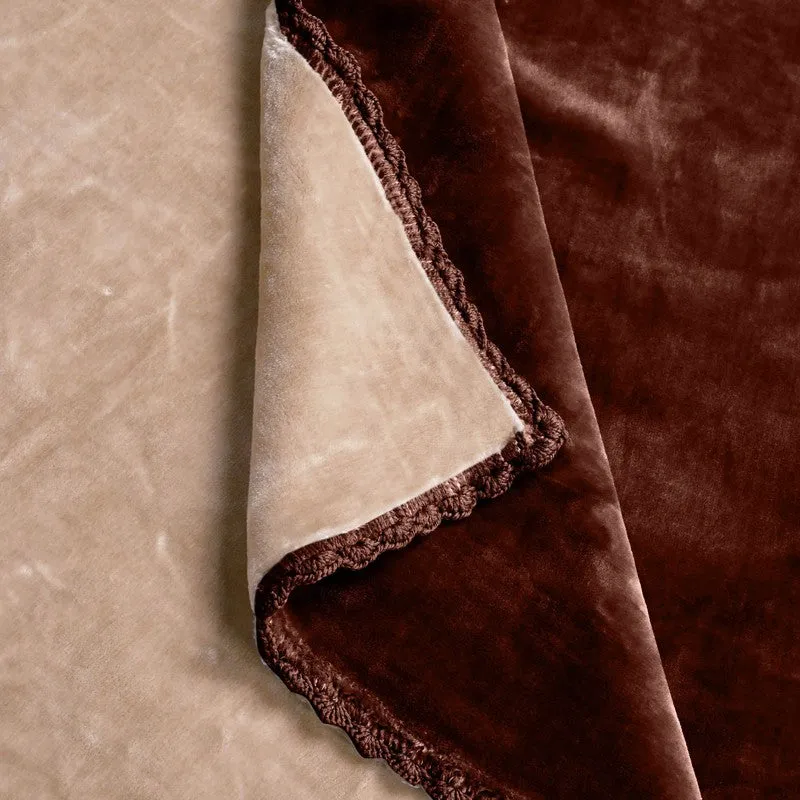 Folded brown and beige blanket showing its soft reverse and decorative edging