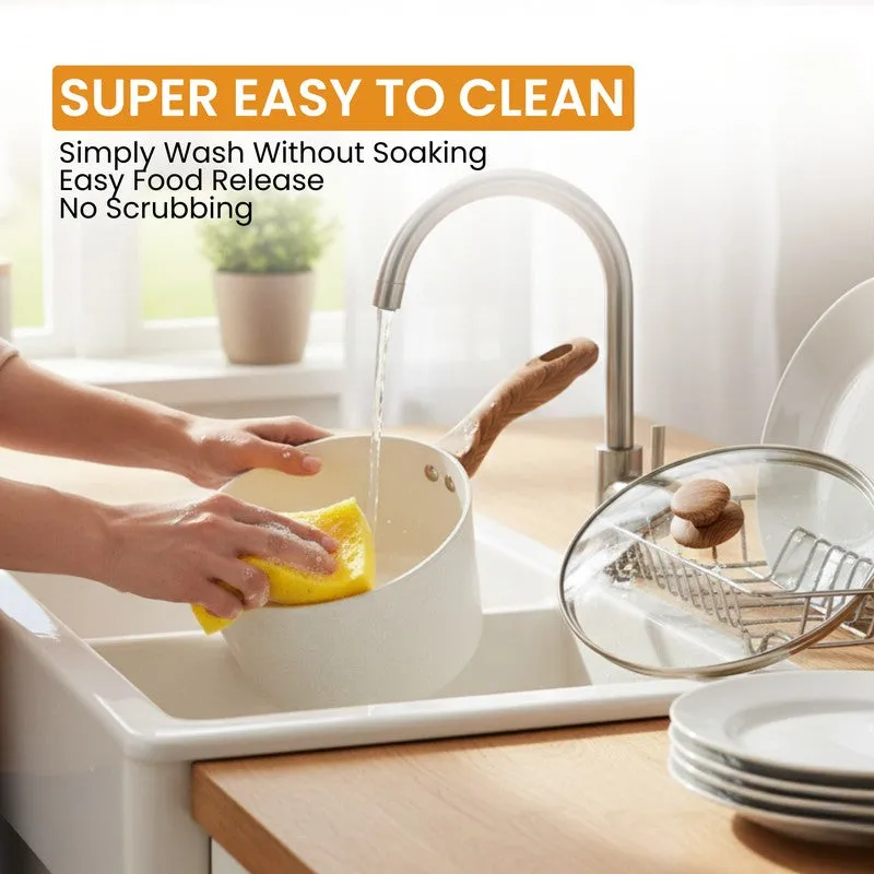 White saucepan being washed by hand beside its glass lid
