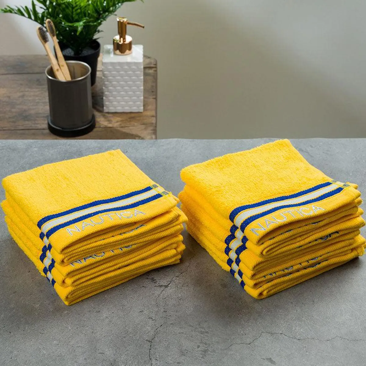Stacks of yellow striped face towels arranged on a grey surface