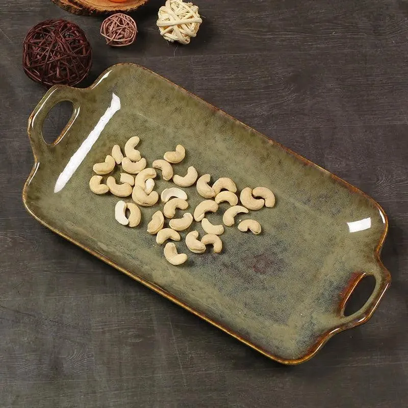 Green handled platter holding cashews, shown from above