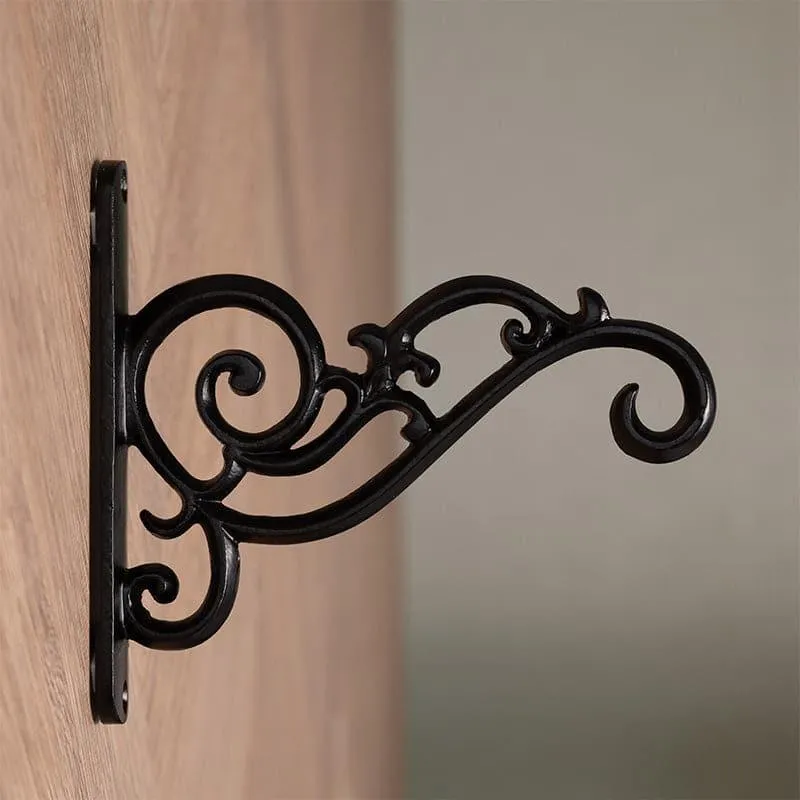 Side view of a black wall bracket showing its curved scrolling silhouette.