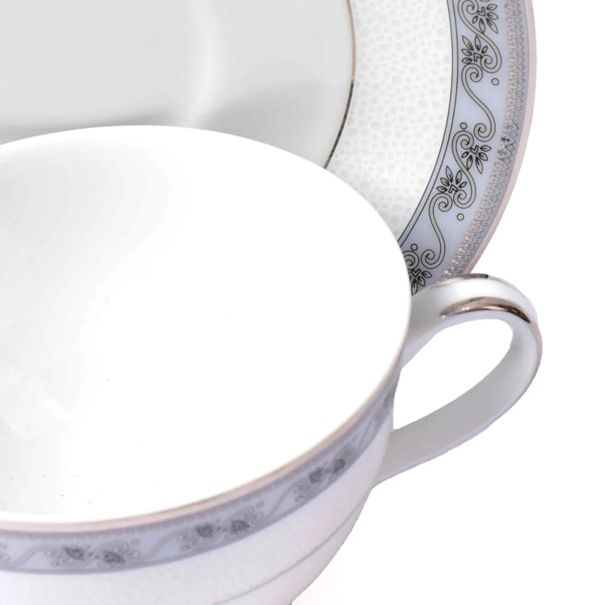 Close-up of white porcelain cup and saucer with grey ornamental border