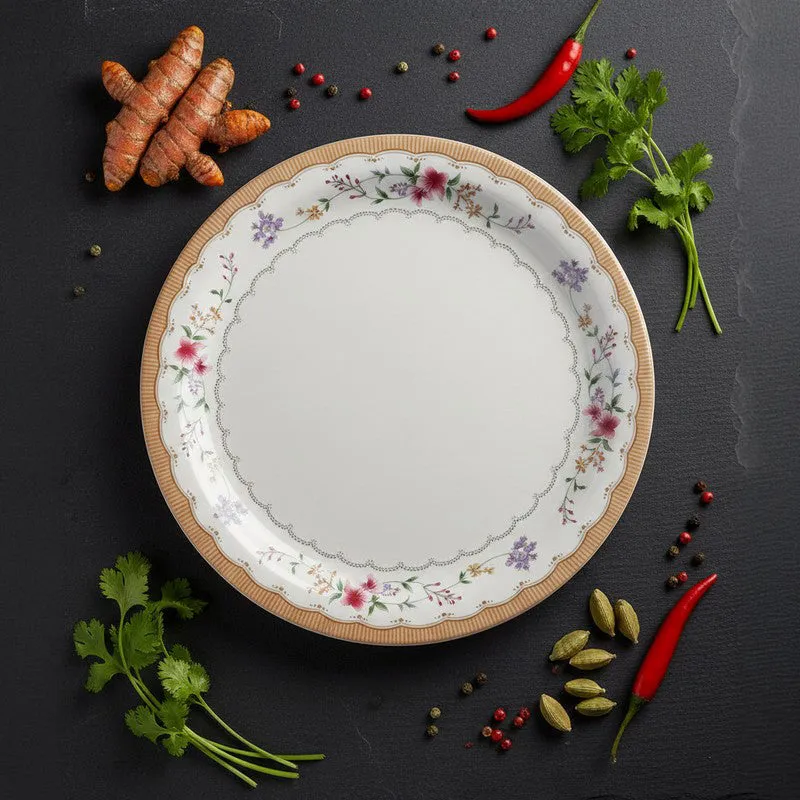 White floral dinner plate styled with herbs, spices and chillies on a dark surface