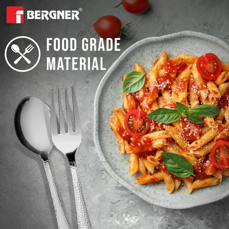 Silver fork and spoon beside a plate of pasta