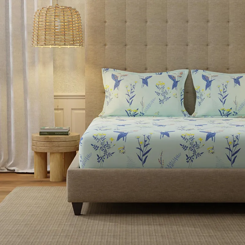 Close view of mint blue bedsheet with matching pillow covers and bird floral print