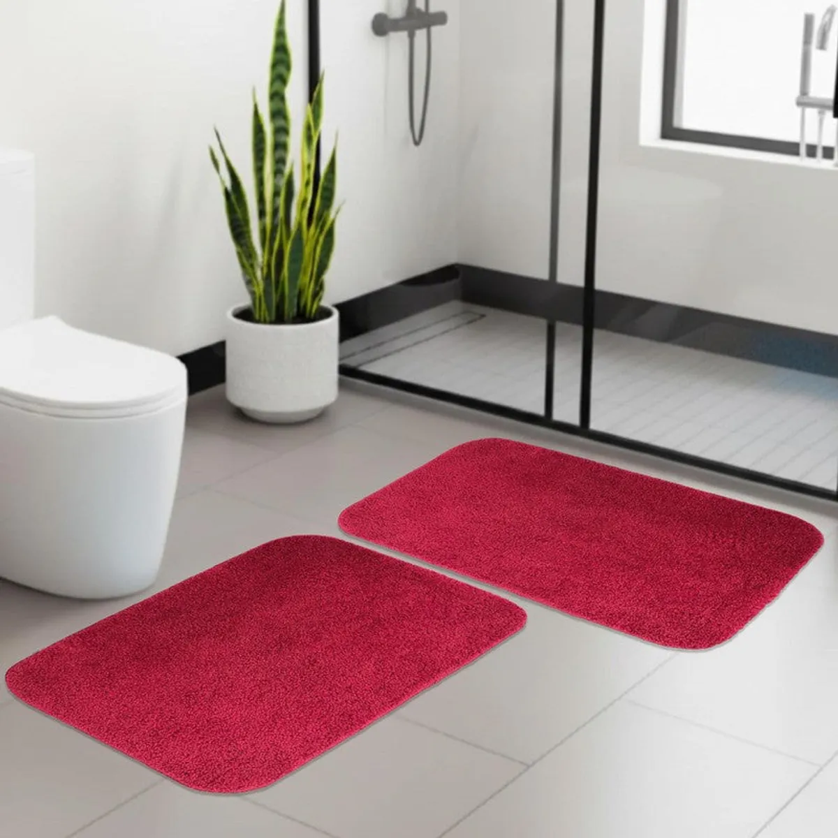 Two maroon bath mats arranged in a modern bathroom