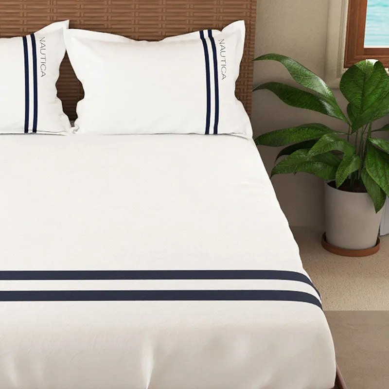 Close view of white bedsheet with navy double stripes and matching pillows