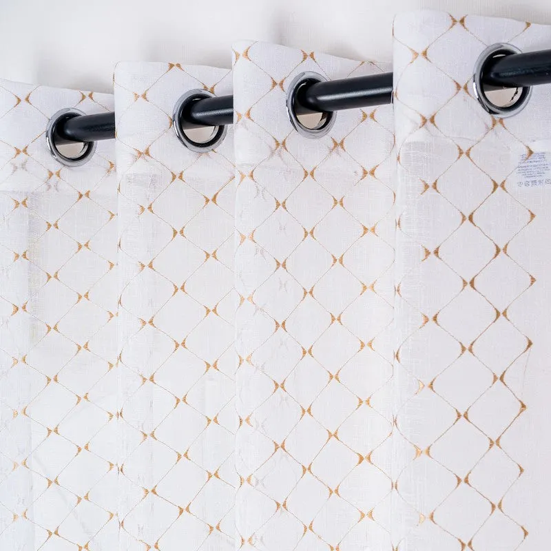 Eyelet header of a sheer curtain with a gold geometric design