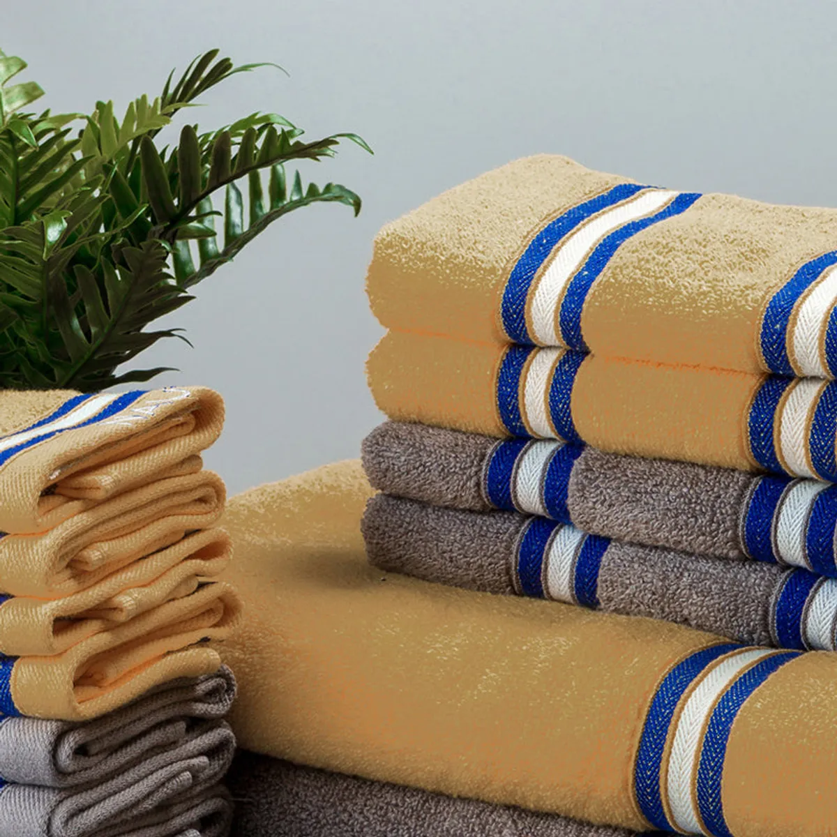 Close view of yellow and grey towels with blue and white stripe borders