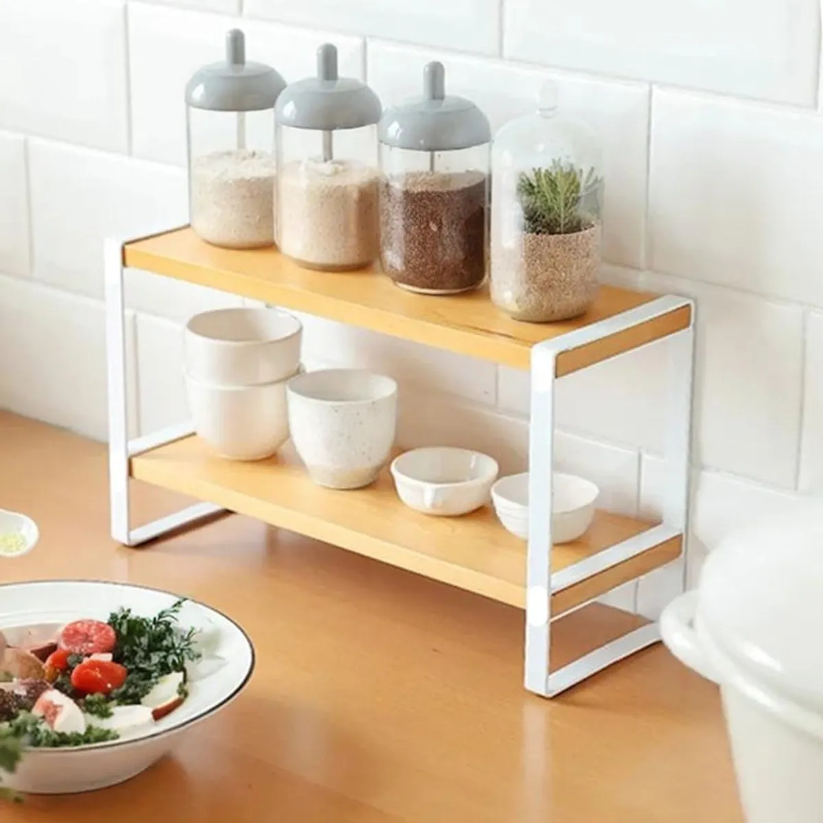 Compact two-tier kitchen rack holding jars, cups and small bowls