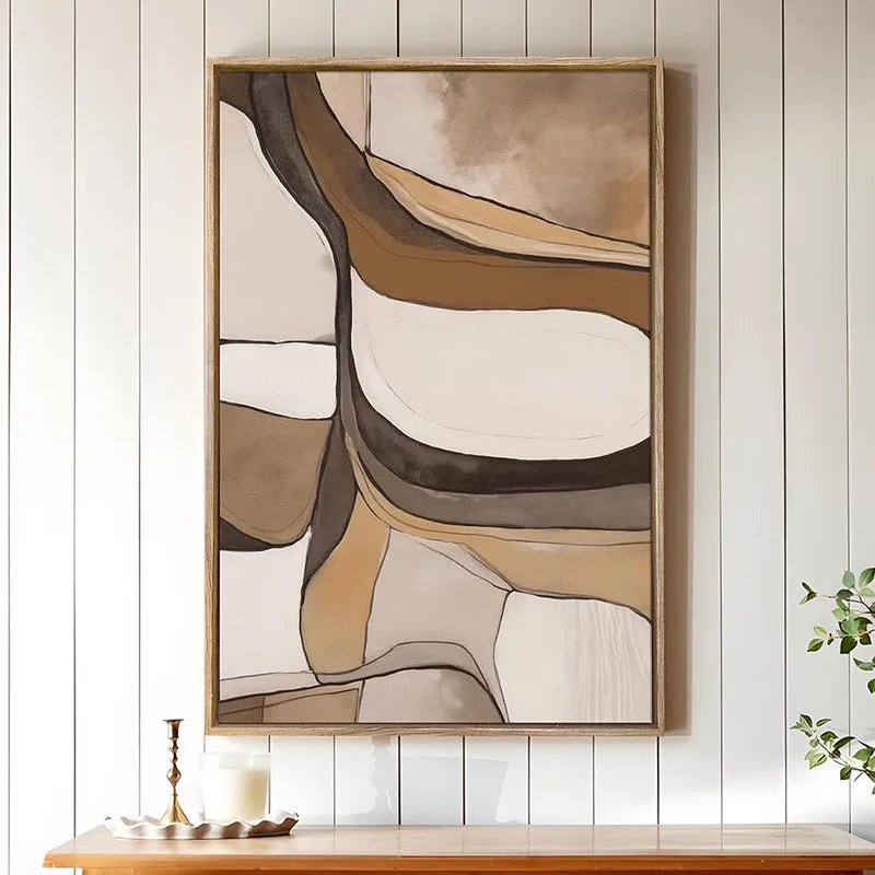 Framed abstract wall art in beige and brown displayed on a white panelled wall
