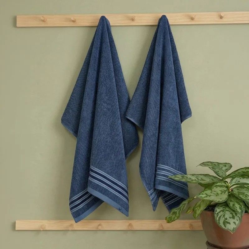 Two blue bath towels hanging on a wooden rack