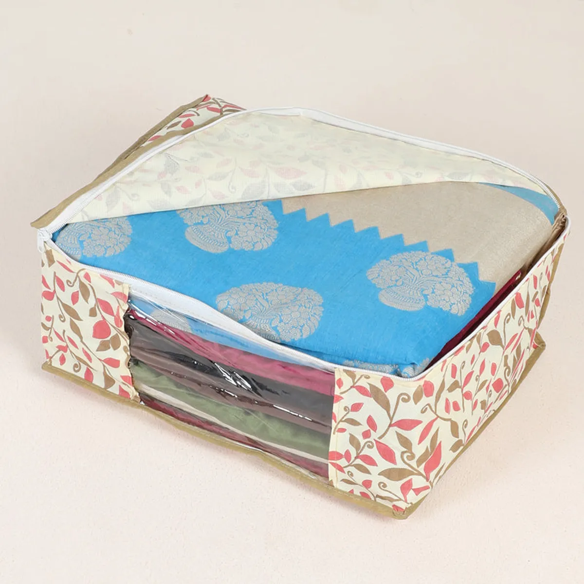 Open floral saree organiser showing folded blue fabric through its transparent front