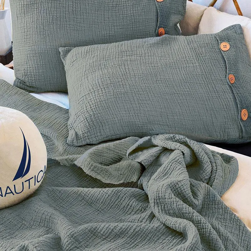 Close view of grey textured bedding and pillow covers with wooden buttons