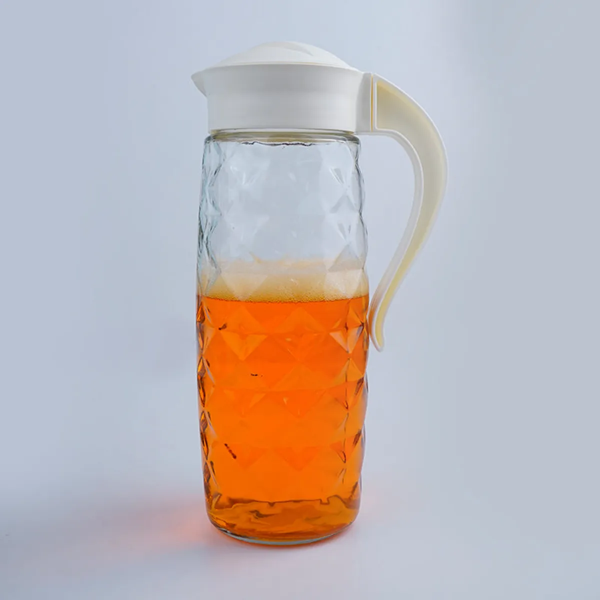 Tall transparent glass jug with white lid and handle