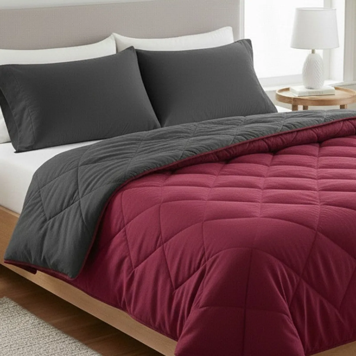 Close-up of the maroon and grey quilted comforter on a bed