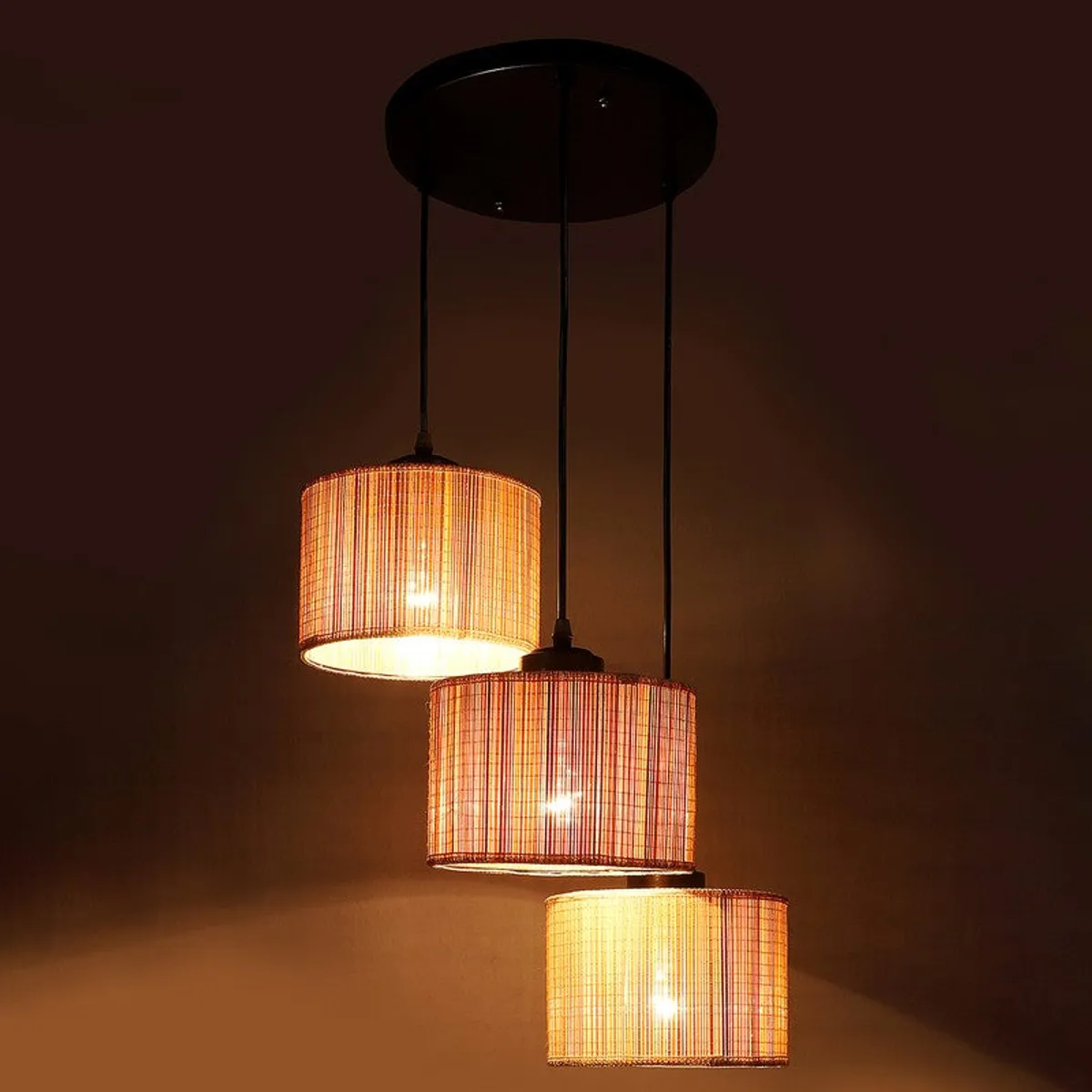 Clustered ceiling lamp glowing warmly against a dark brown background