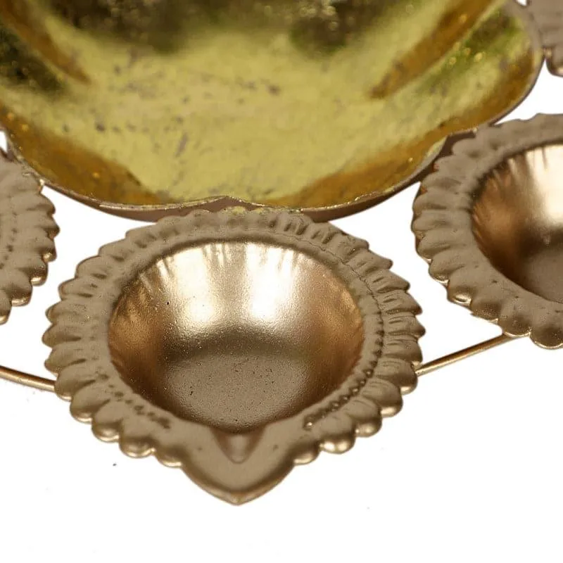 Close-up of a gold petal-edged diya holder attached to the urli frame