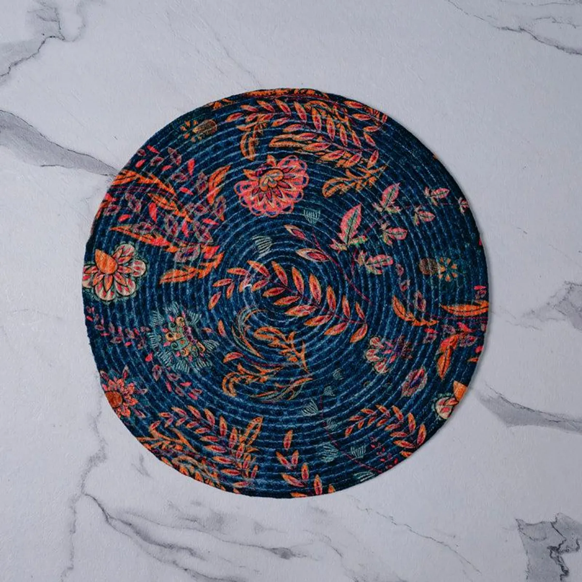 Single round deep blue table mat with a colourful floral print