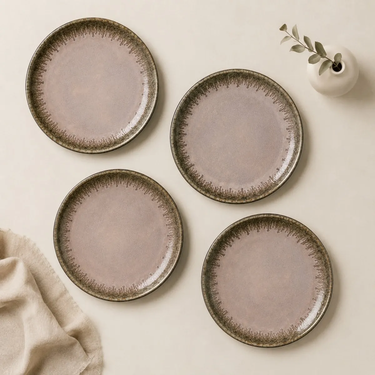 Four glossy pink ceramic plates arranged in a square layout