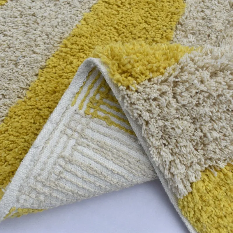 Close-up of folded bath mat showing striped backing and textured pile