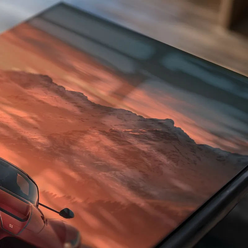 Close-up of poster surface showing red sports car and mountain scene