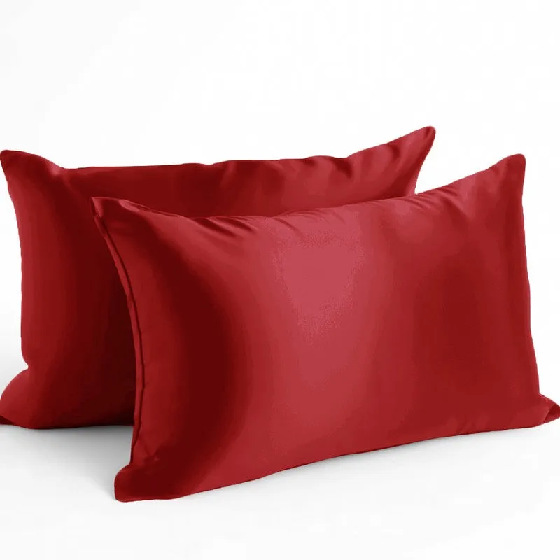 Two red satin rectangular pillow covers against a white background