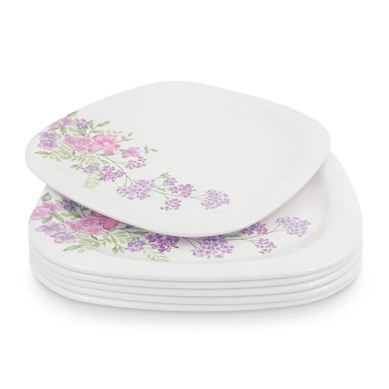 White square floral dinner plate resting on a stack of matching plates