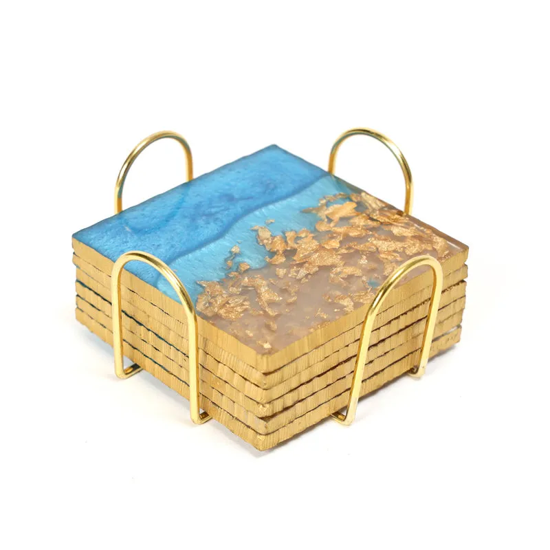 Stacked square coasters in a gold stand on a white background