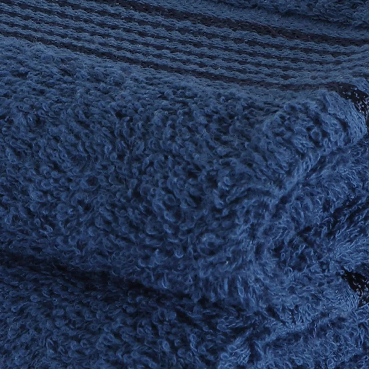 Close-up of plush navy blue towel texture with subtle horizontal stripes.