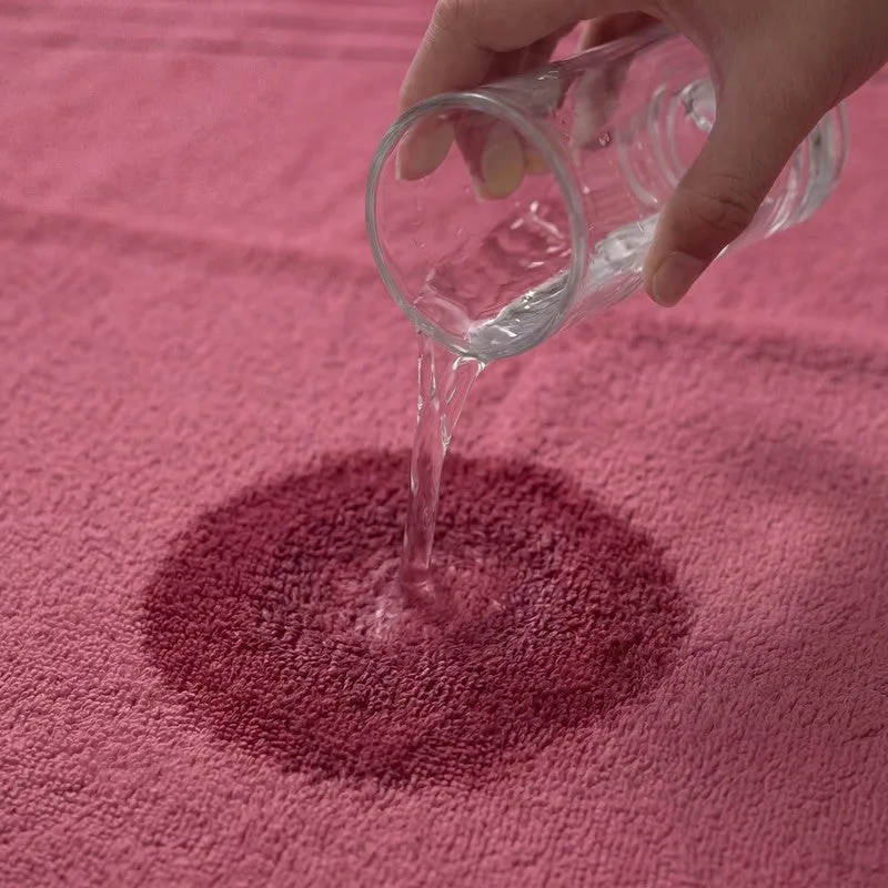 Close-up of water poured onto dusty pink bath towel