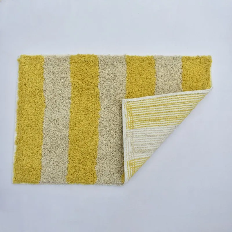 Yellow and white striped bath mat with one corner folded up