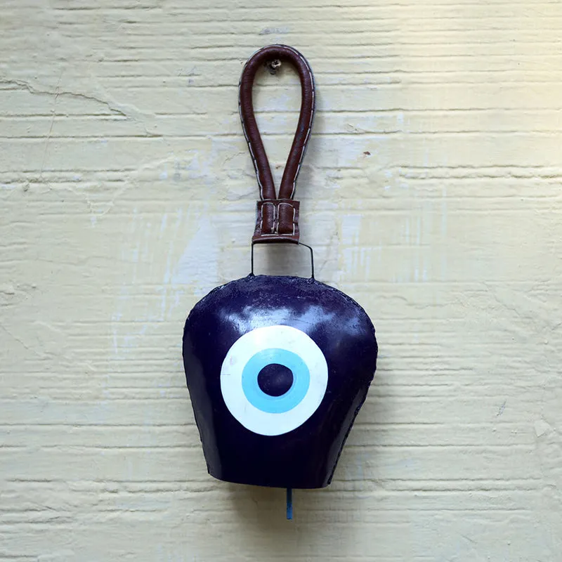 Front view of a black metal bell with blue and white eye motif