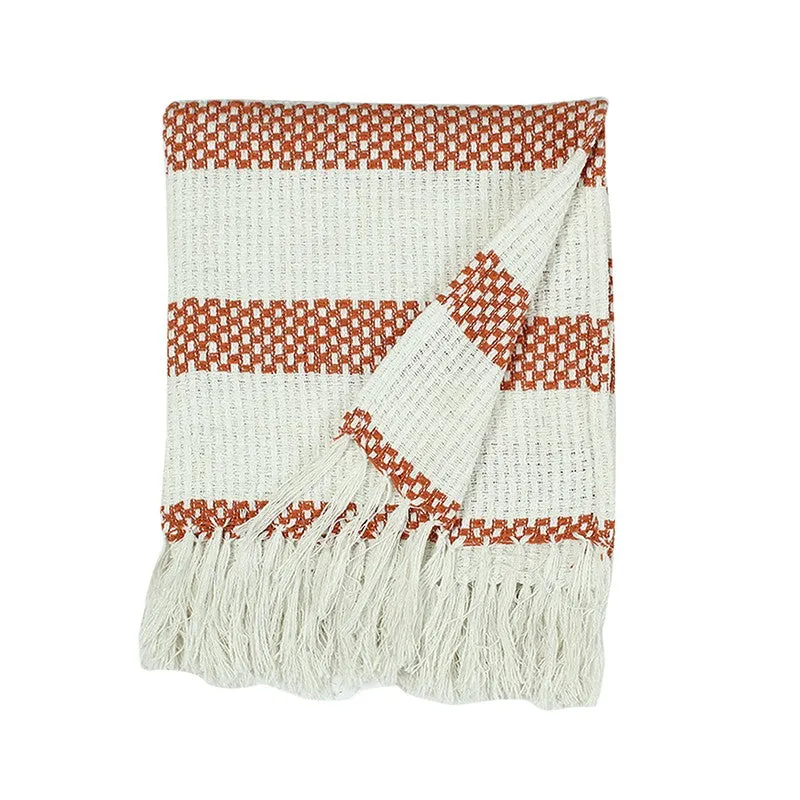 Orange and cream throw shown folded back to reveal its patterned surface