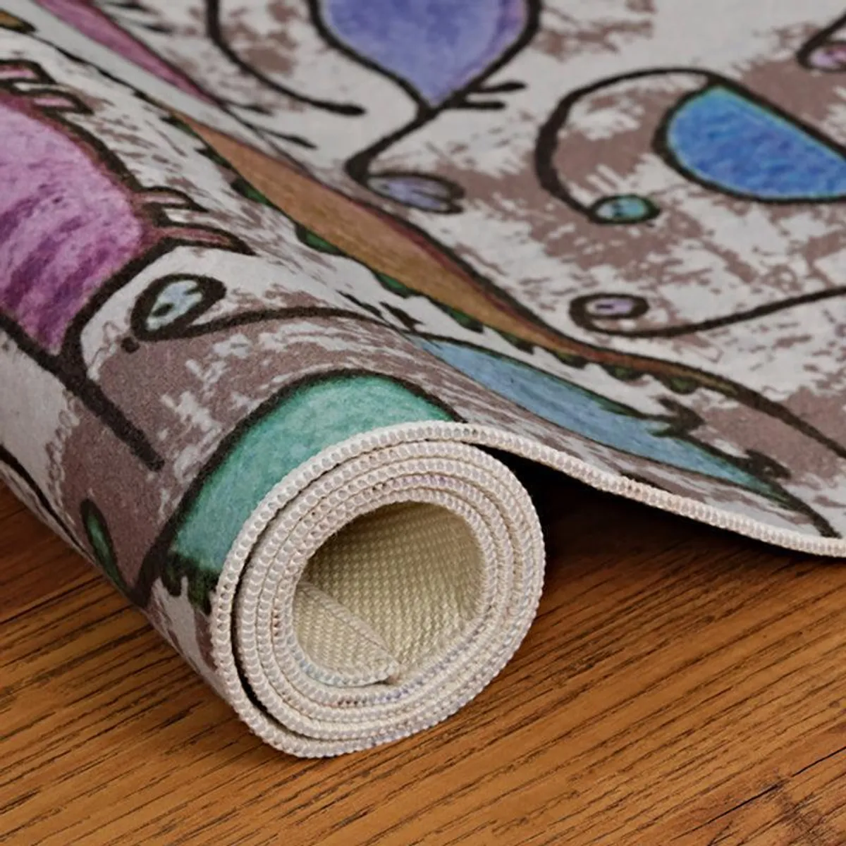 Rolled edge of the dinosaur print carpet showing thickness