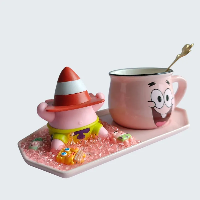 Angled view of pink character mug, red hat figurine and gold spoon on tray