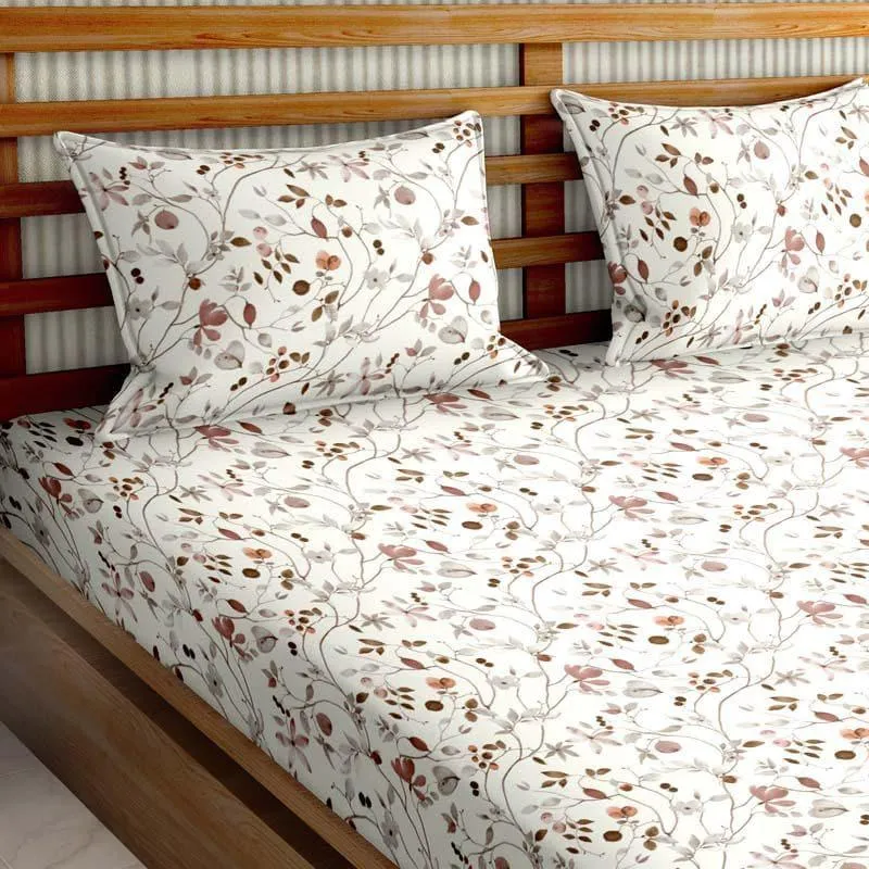 Floral brown and pink bedsheet and pillow covers styled on a wooden bed