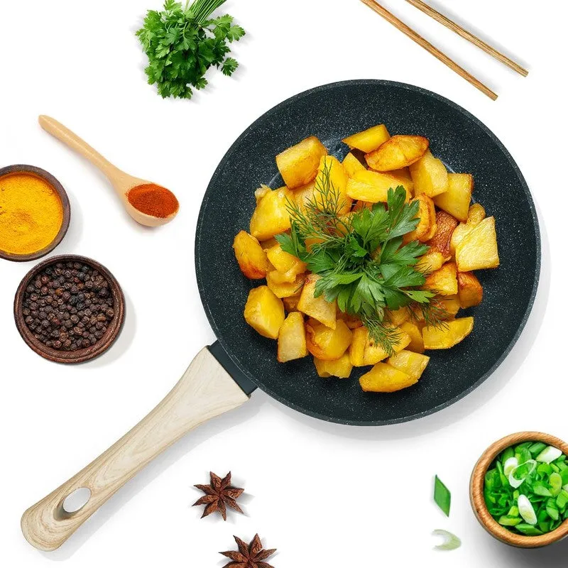 Black frying pan filled with roasted potatoes and garnished with fresh herbs