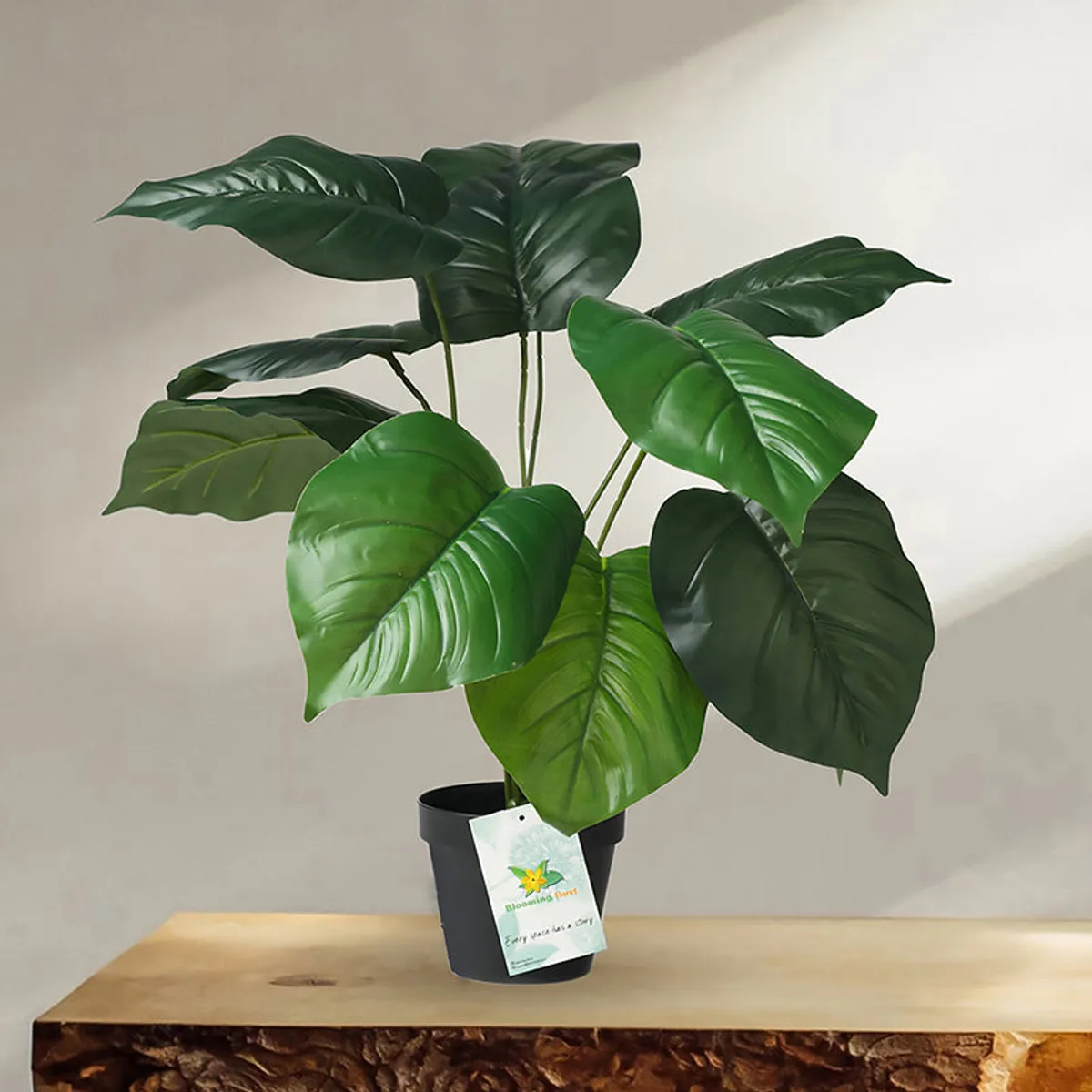 Artificial green philodendron plant with multiple leaves in a black plastic pot